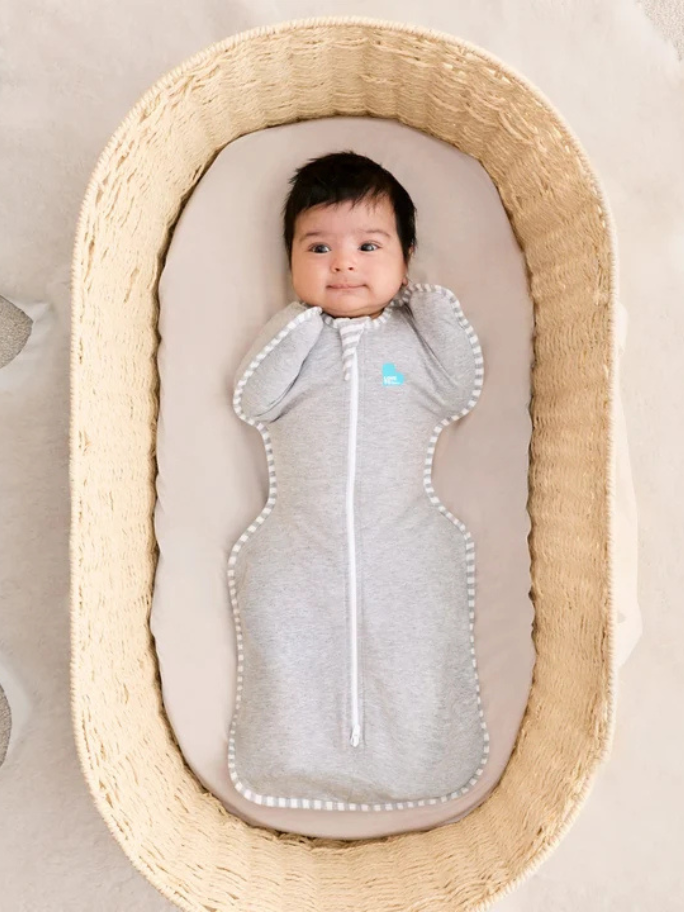 Baby in a moses basket wearing a Love to Dream Swaddle