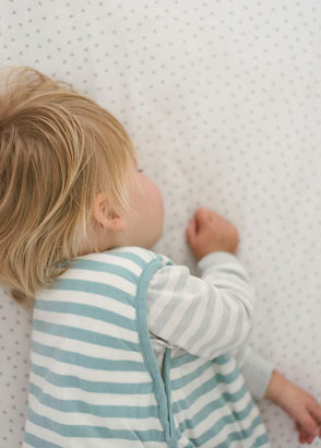 Toddler sleeping while wearing Woolbabe tide duvet weight sleeping bag