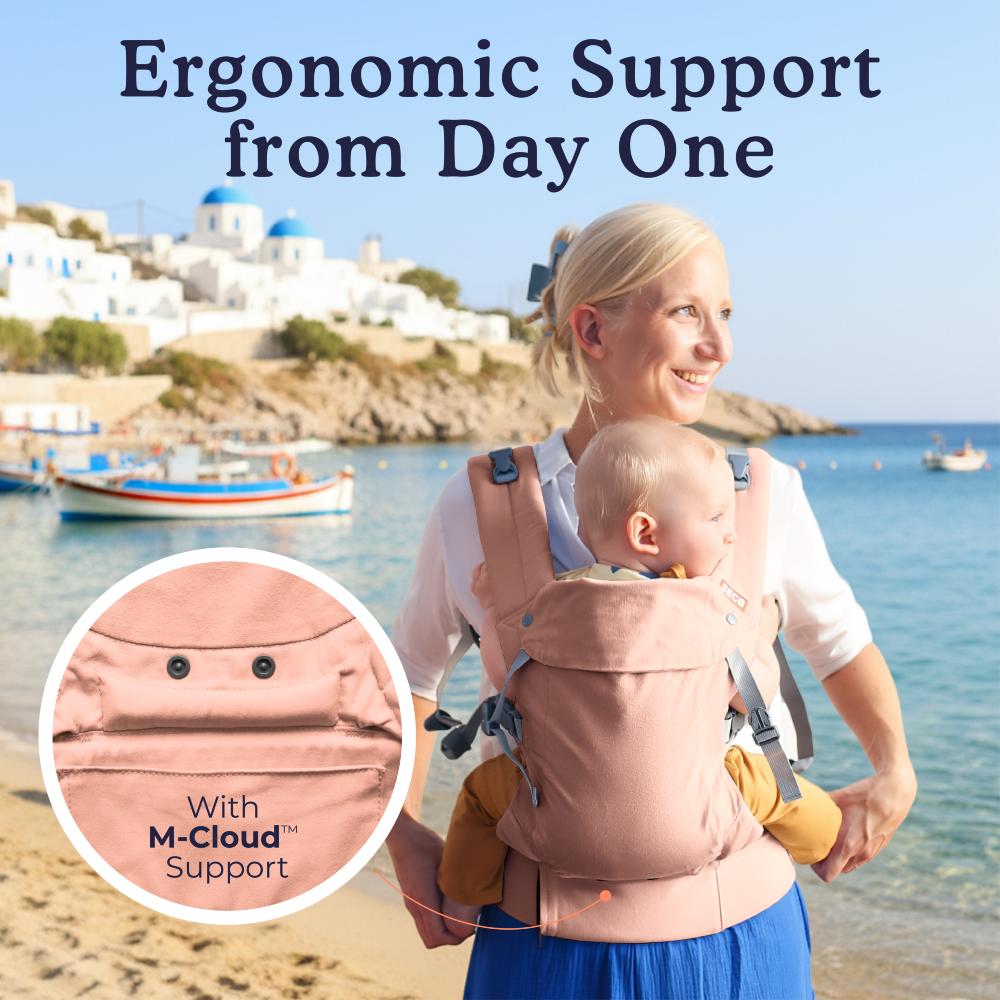 Pink cotton Beco Carrier worn by a woman at the beach with a 6 month old baby