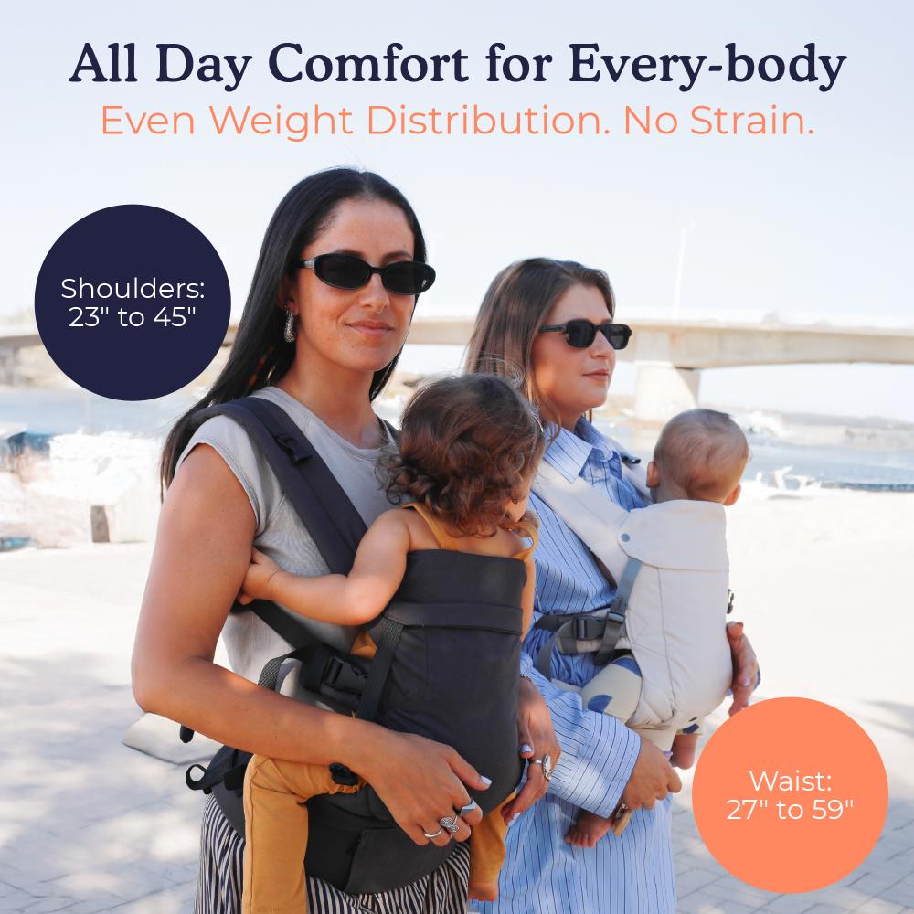 Two women with children using cotton Gemini V2 baby carriers by a waterfront.
