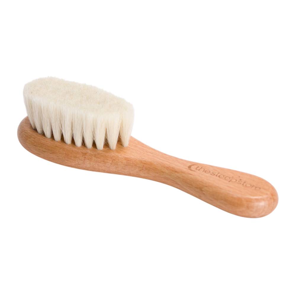 Wooden baby brush with natural bristles on a white background
