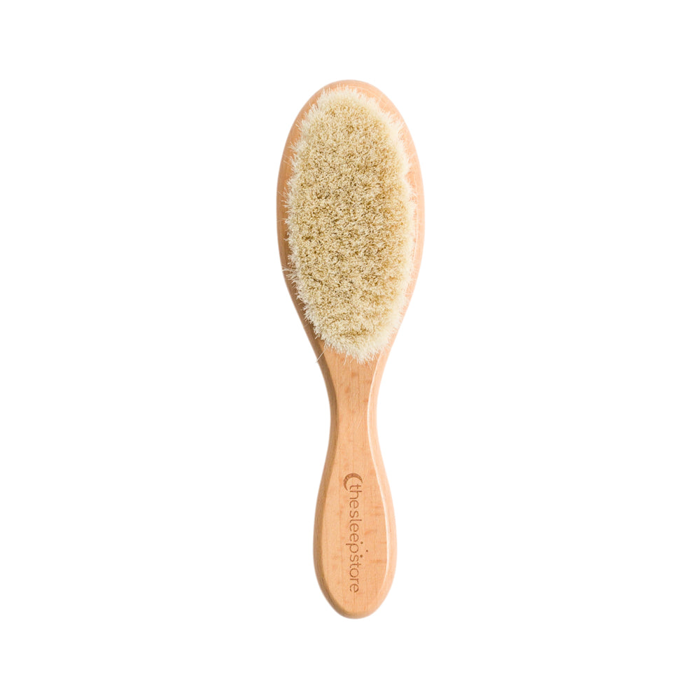 Wooden toddler baby brush with natural bristles on a white background