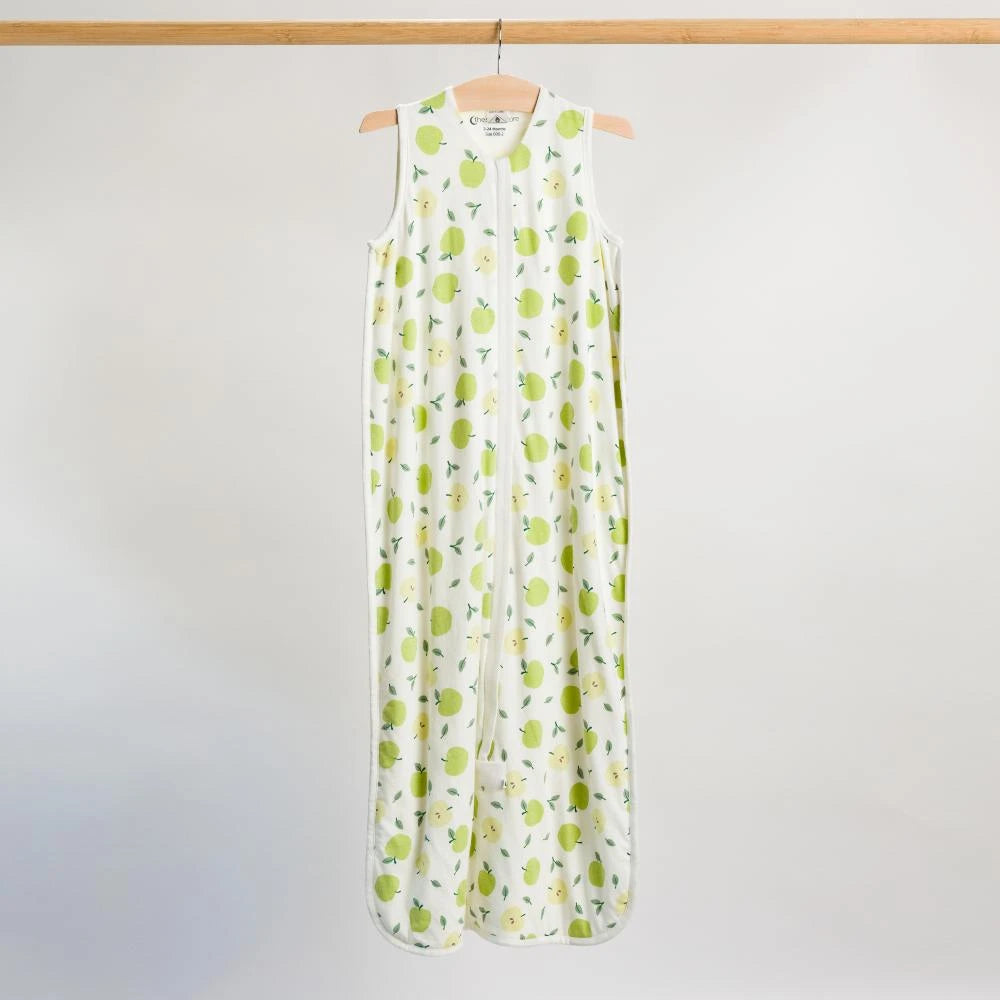 Hanging shot of a baby sleeping bag with an all over apple print. 