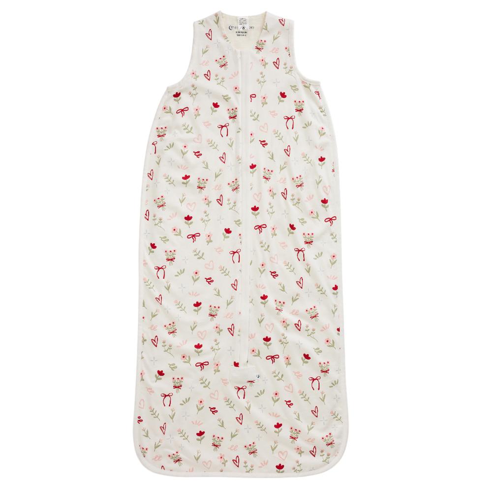 A sleeveless baby sleep sack with a front zipper, featuring an all-over print of small flowers, and hearts in red, pink, and green on an off-white background.