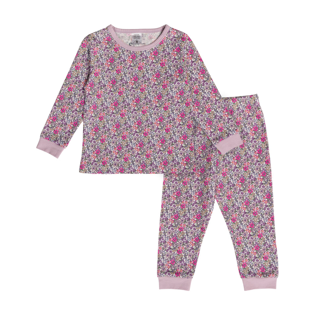 Child in cotton purple floral print pyjamas on a white background