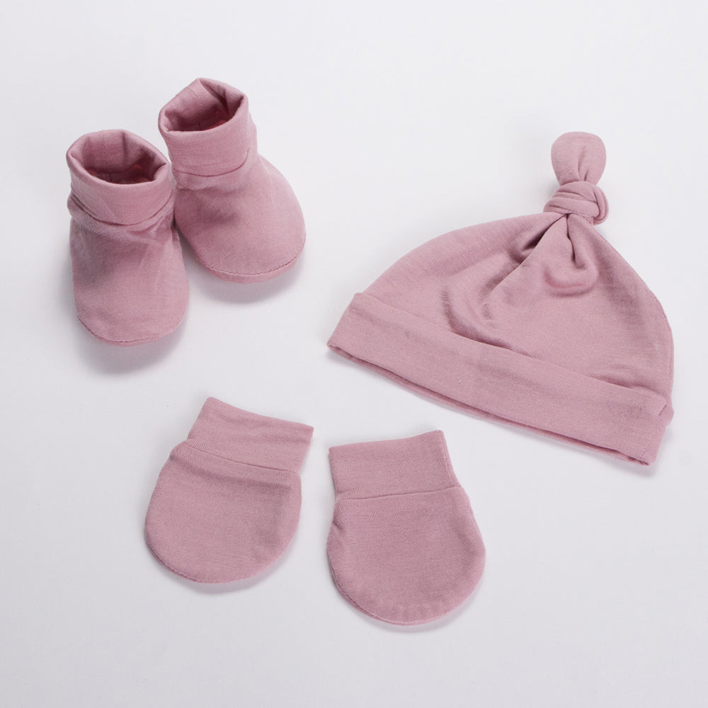 Set of Merino Booties, Beanies and Mittens in Pink on a white background