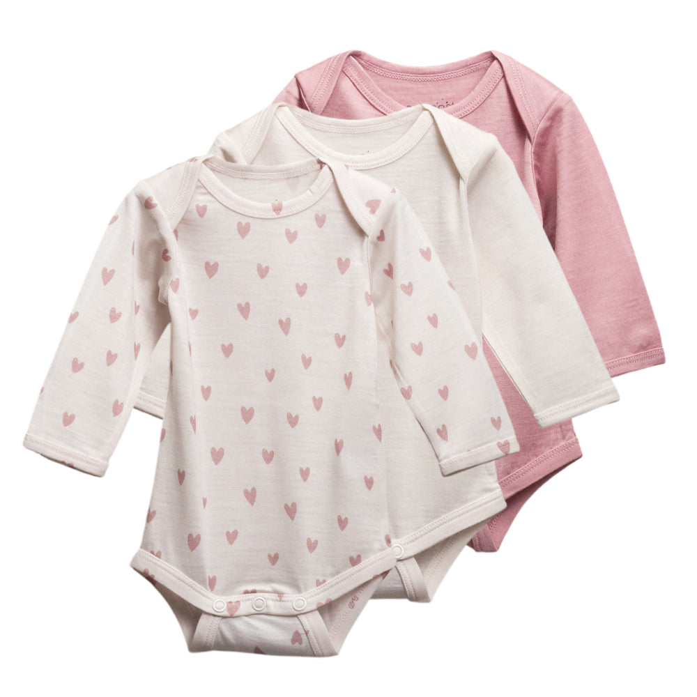 3 pack of long sleeve merino bodysuits in cream, pink and hearts print on a white background