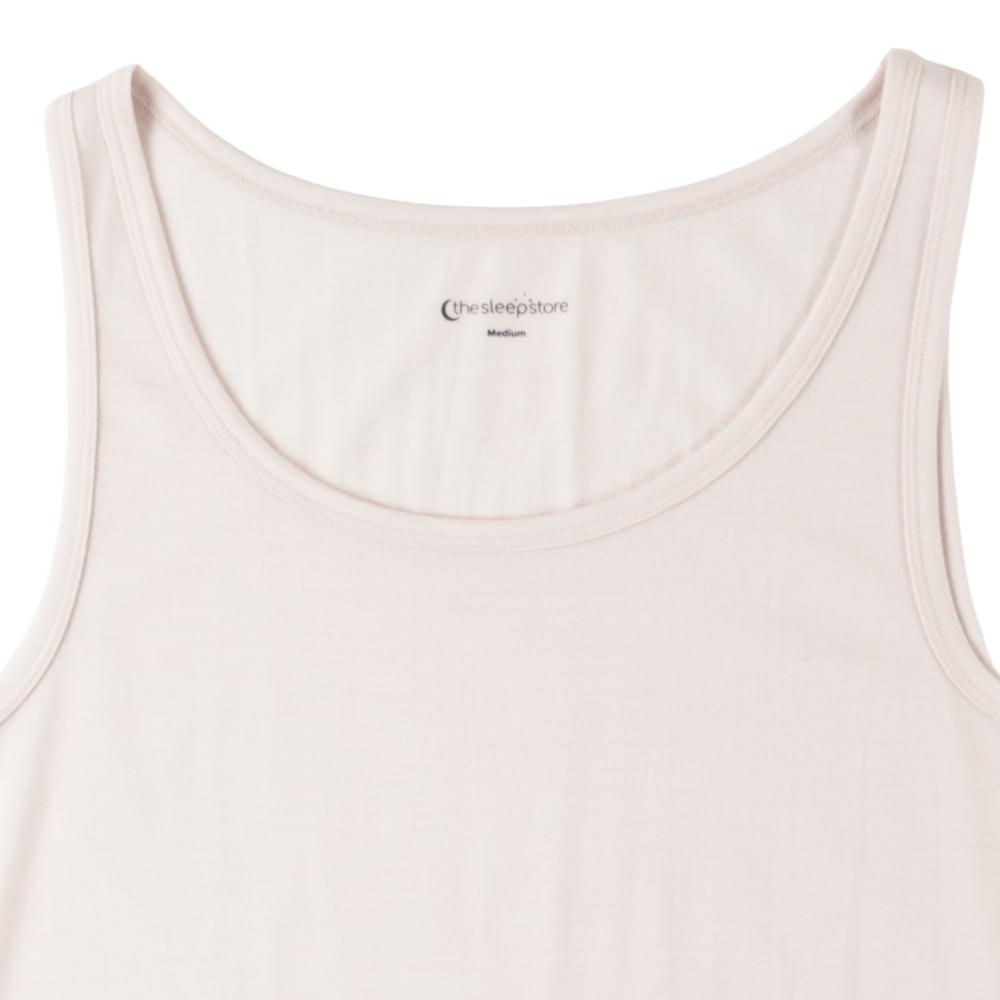 A close-up of a white tank top showing the inner neckline with the brand name 'the sleepstore' and size 'Medium' printed inside.