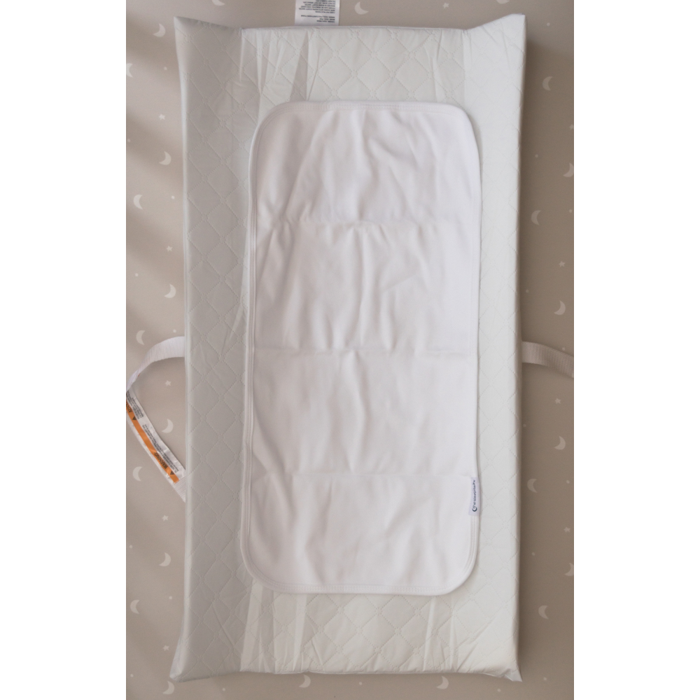 White baby changing pad liner on a changing pad.