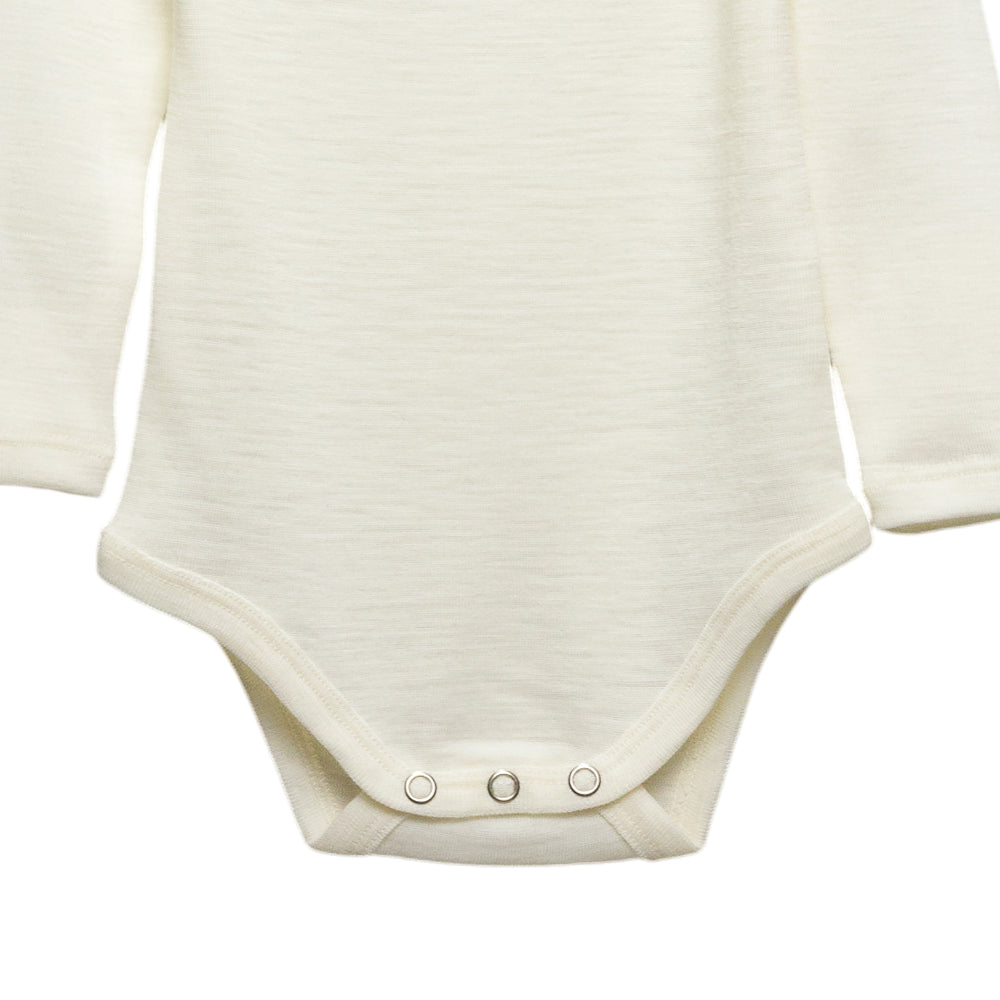 Close-up of a long-sleeve baby bodysuit in a cream color, showing the chest and snap-closure crotch area on a plain white background.