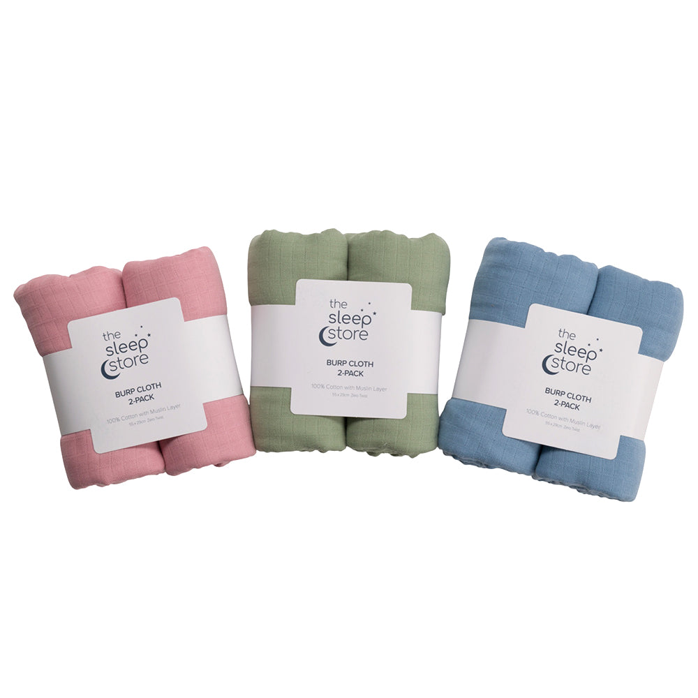 Three packs of 'The Sleep Store' burp cloths in pink, green, and blue on a white background.