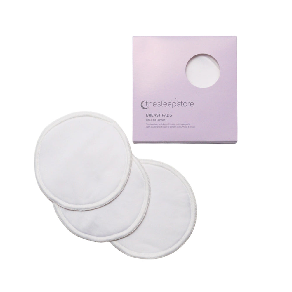 Three white reusable fabric breast pads displayed next to their light purple packaging box on a clean white background.