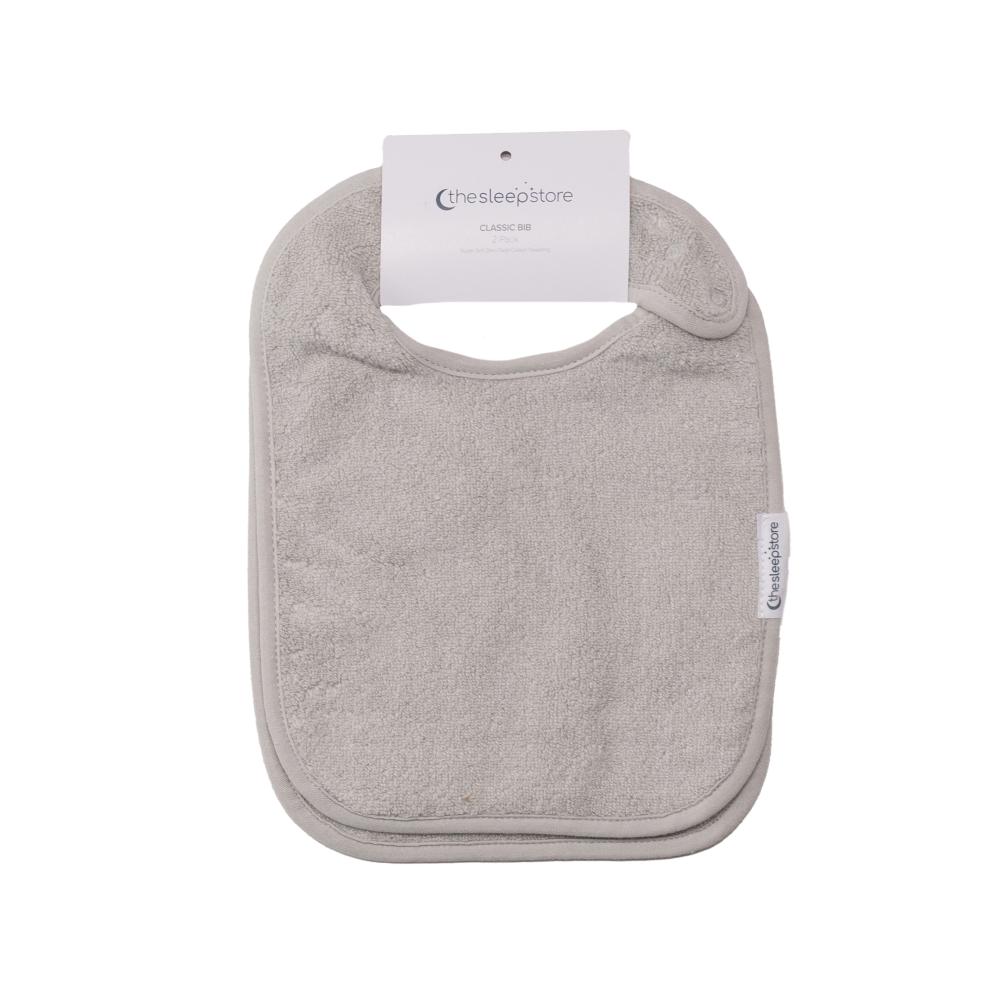 Gray towelling classic baby bib with a label on a white background