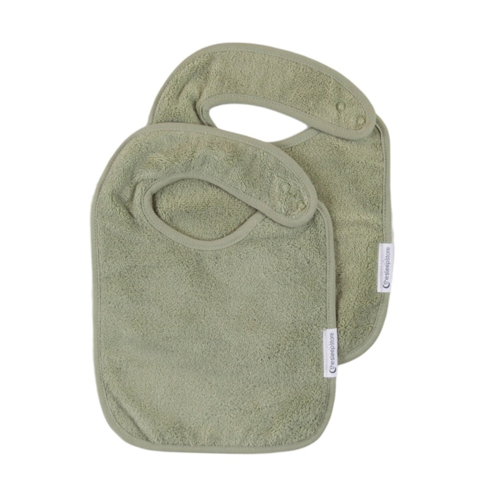 Two green cotton terry bibs on a white background
