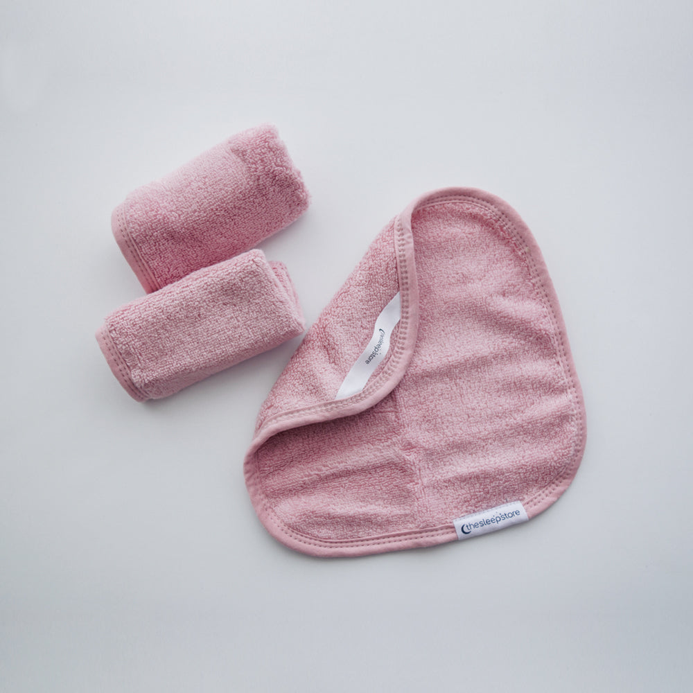 Pink textured washcloth towel set on a light gray background