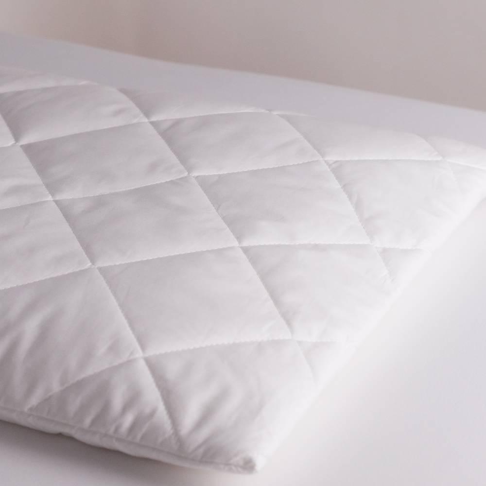 White quilted pillow on a neutral background