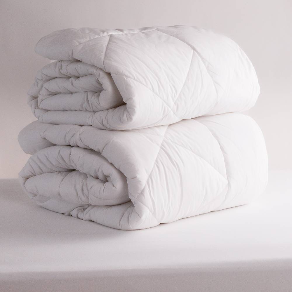 2 White Duvet Inners rolled up on a white background