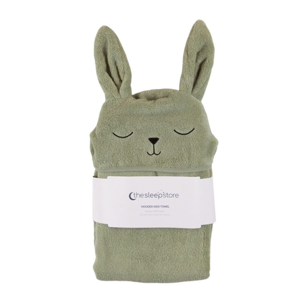 A sage green cotton terry hooded toddler towel shaped like a bunny with closed eyes, featuring a white paper label from 'thesleepstore' wrapped around the middle, set against a plain white background.