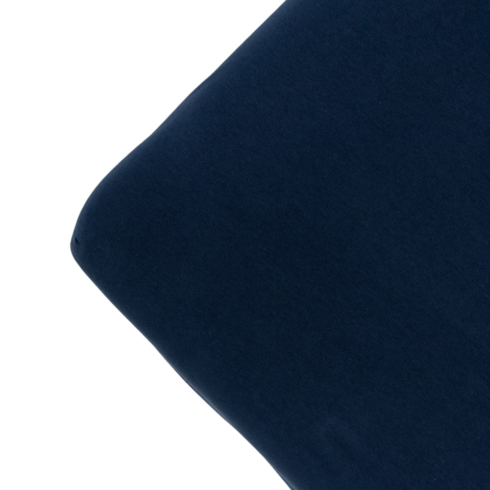 The corner of a mattress with a navy colour fitted sheet, on a white background. 