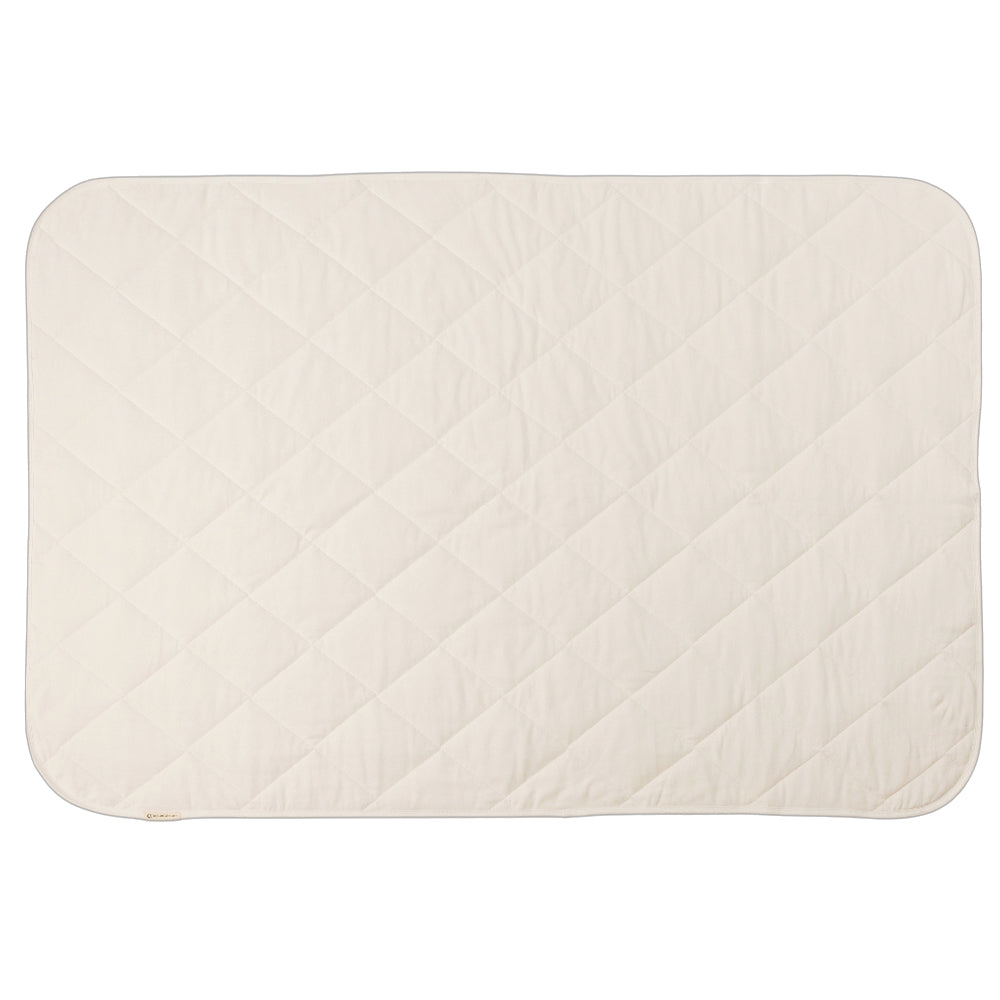 A natural cream colour quilted blanket on a white background. 