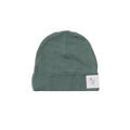 Green merino baby beanie with a white label on a white background