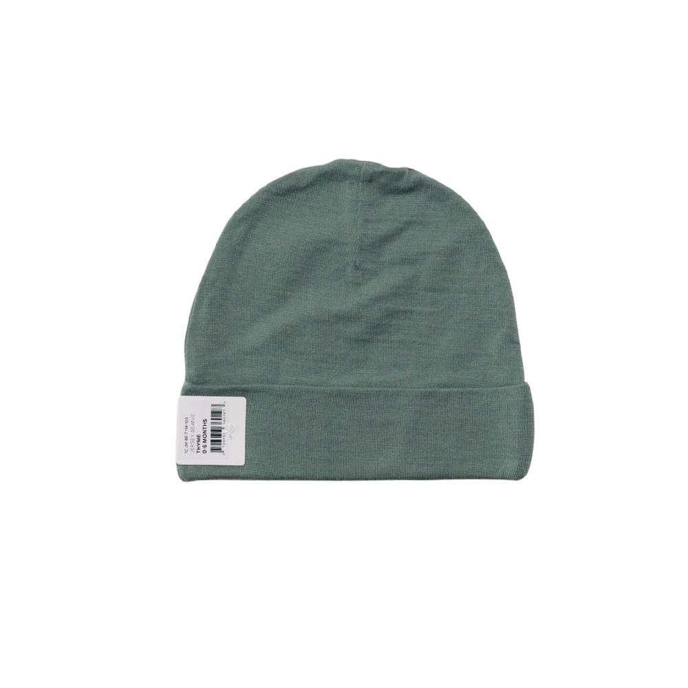 Green merino baby beanie with a label on a white background