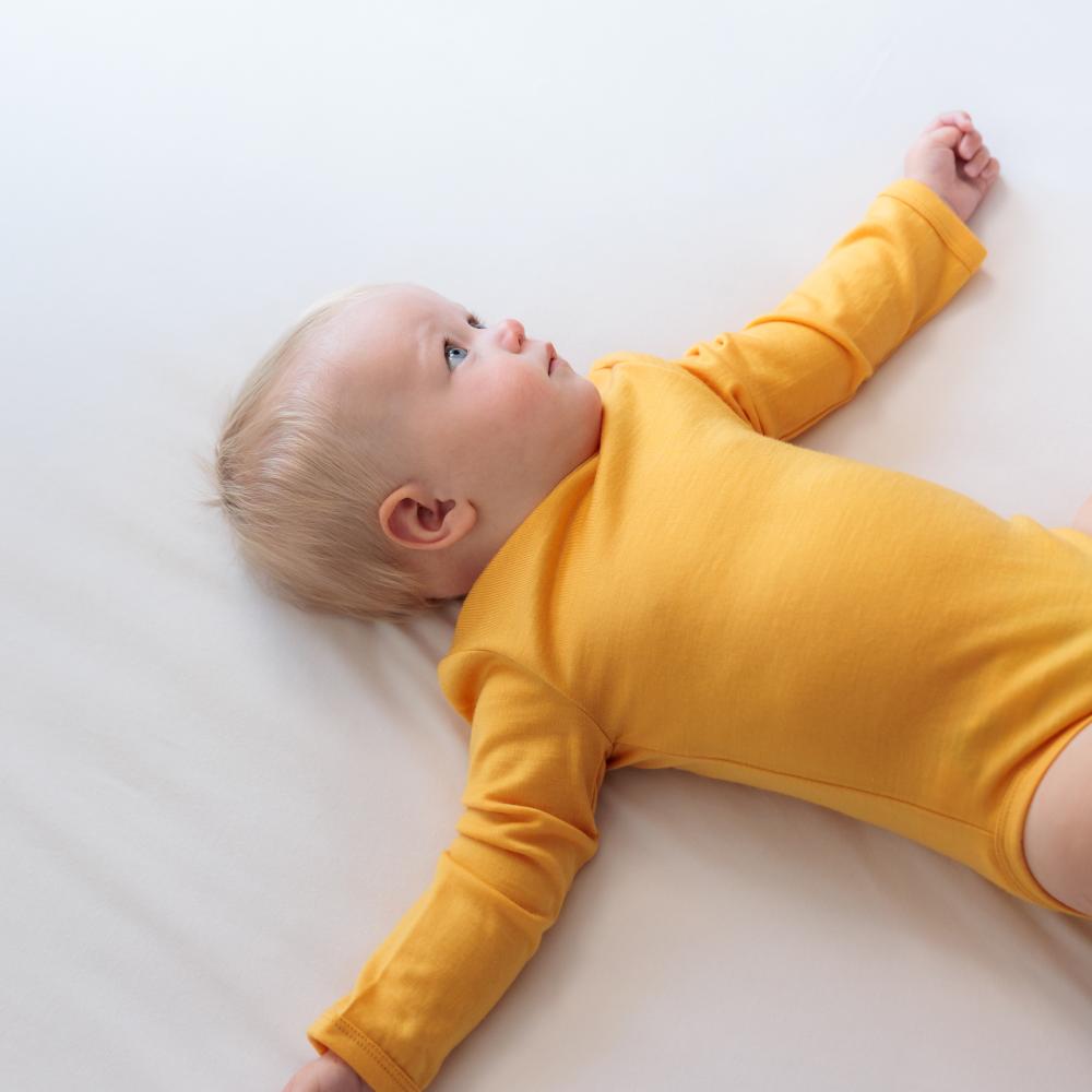 Baby in golden yellow merino bodysit