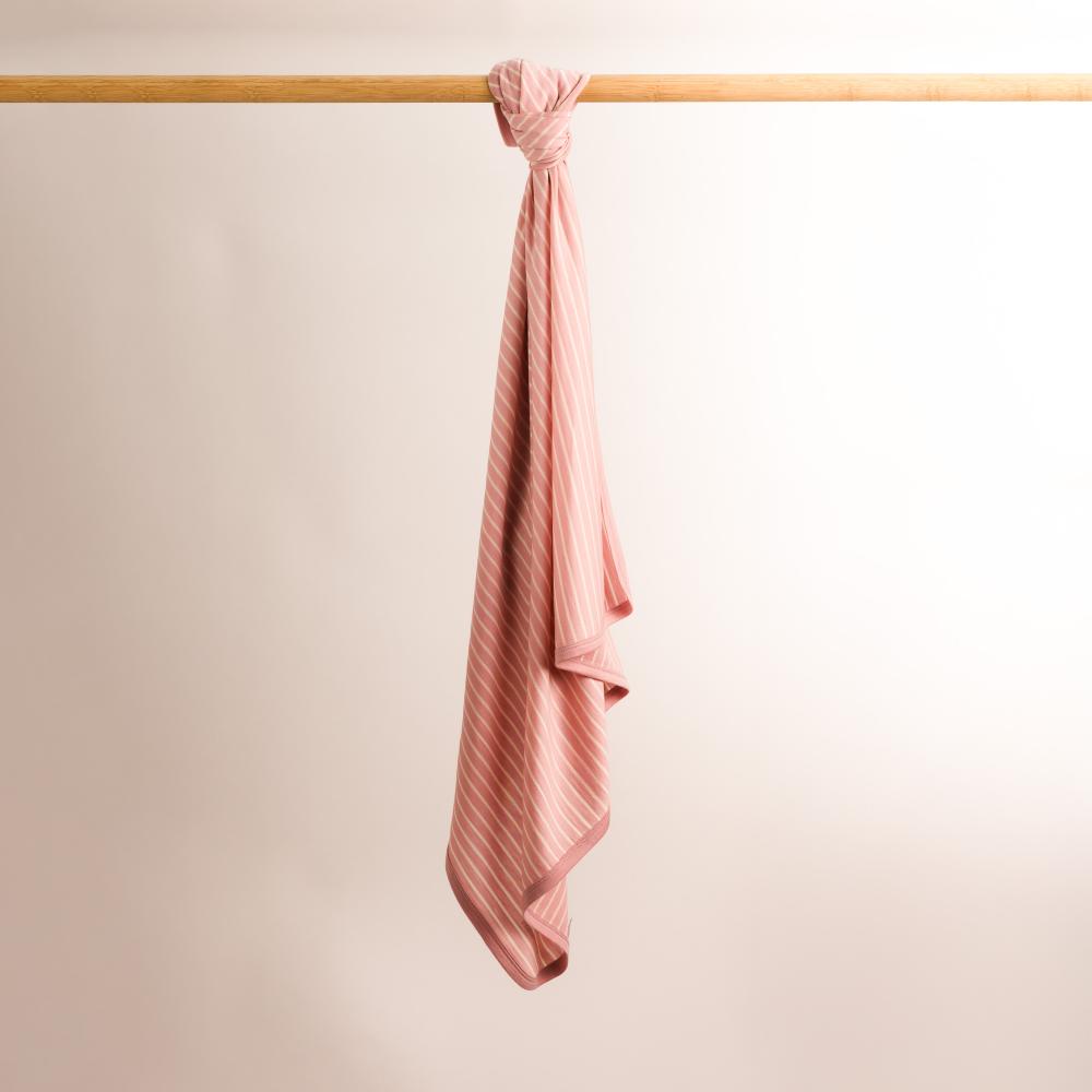 The sleep store merino swaddle blanket hanging from rail
