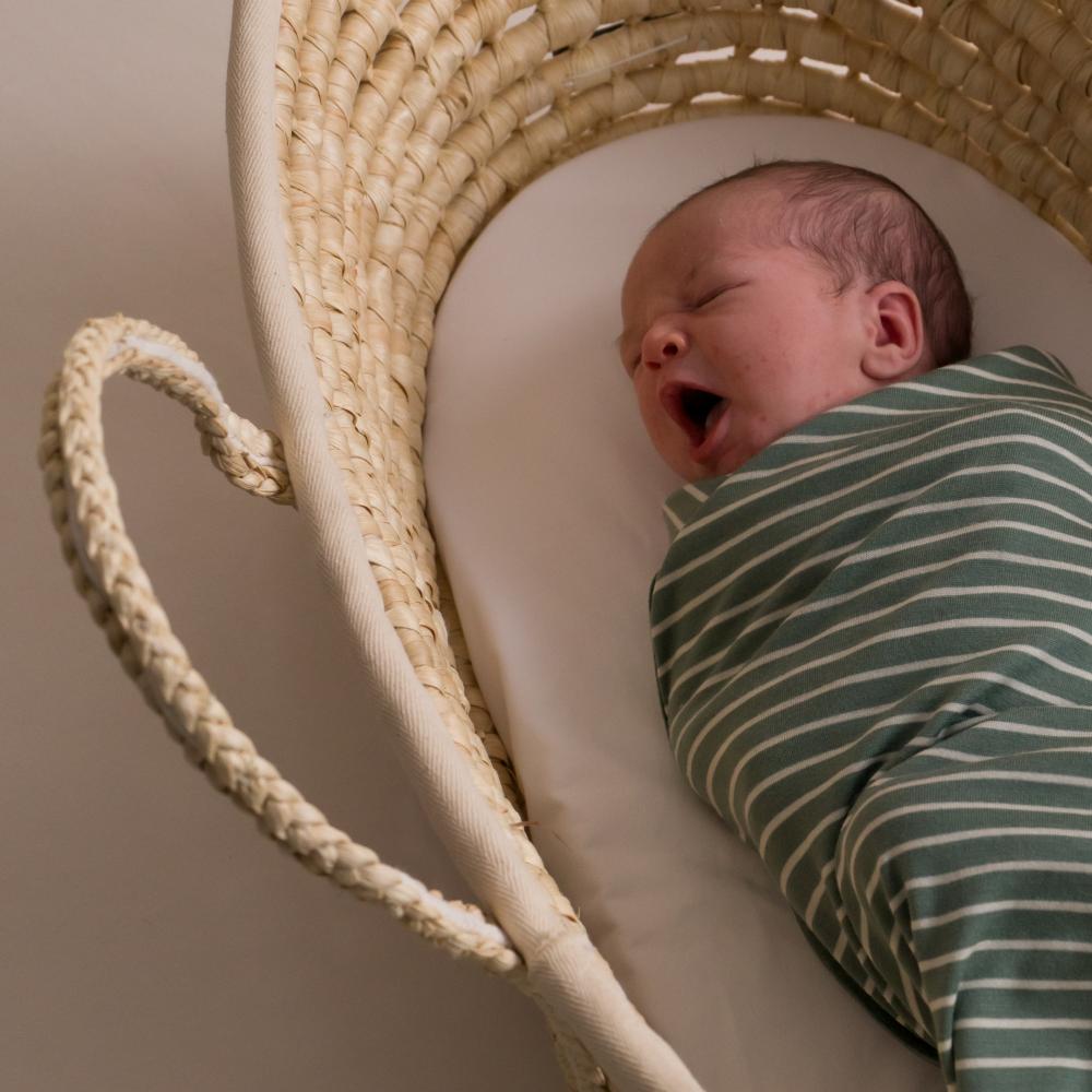 Newborn baby swaddled in merino blanket by the sleep store