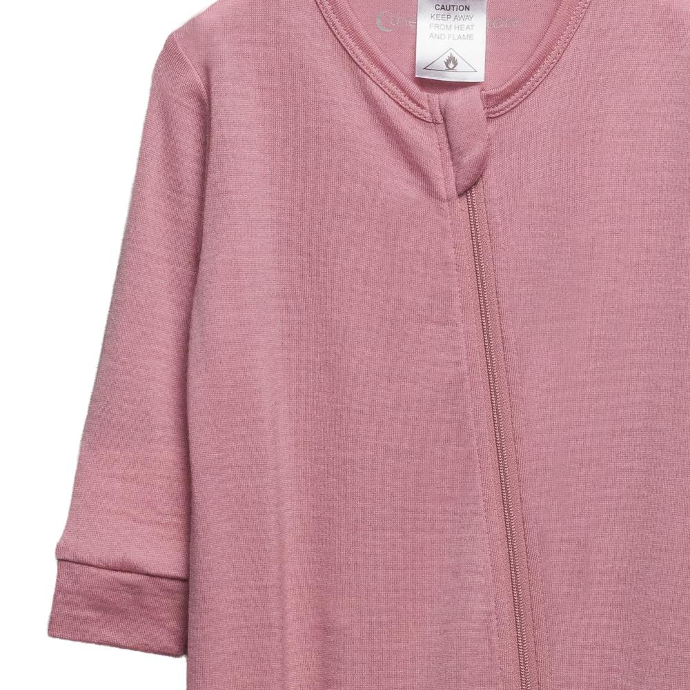The sleep store pink merino baby onesie with a zipper on a white background