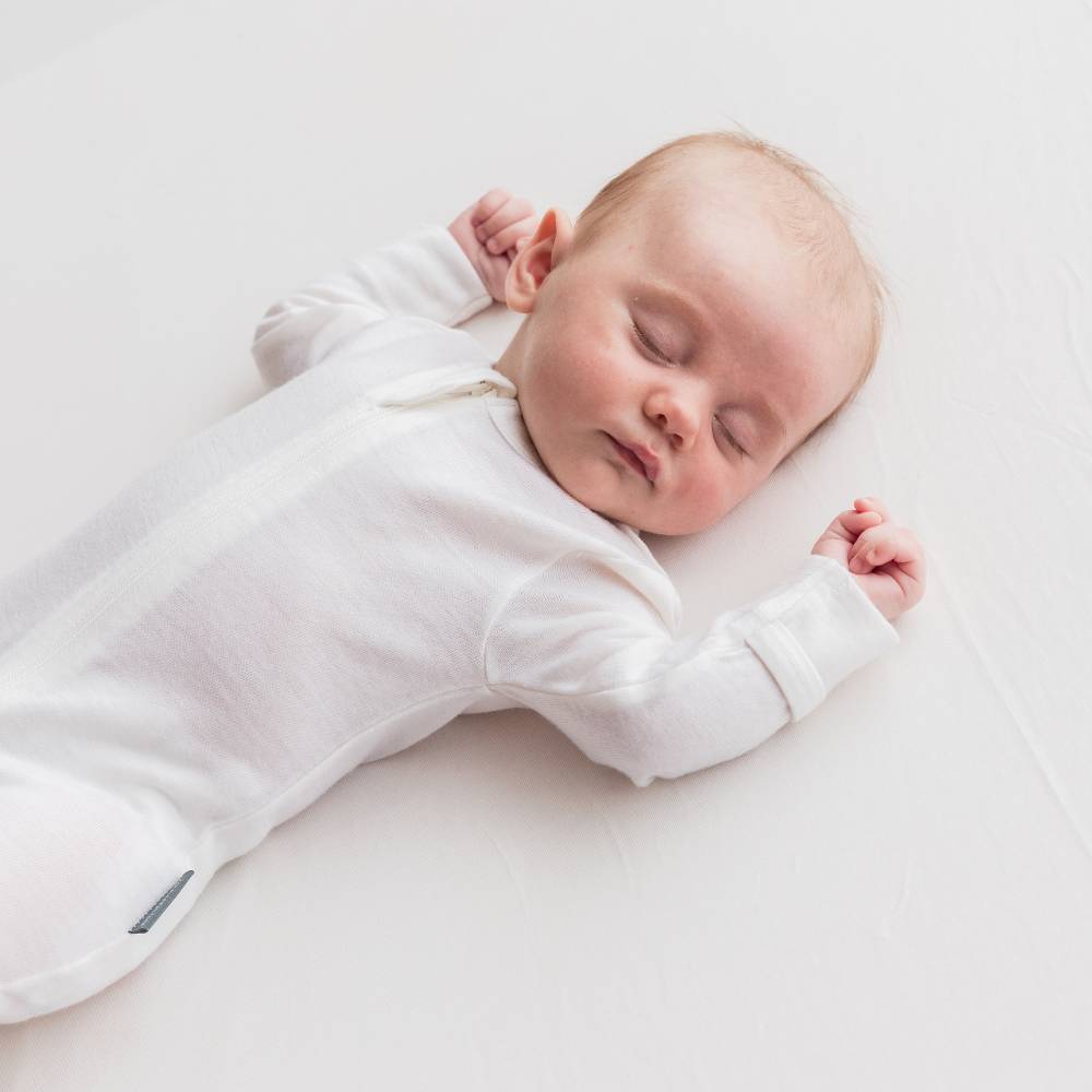 Newborn baby wearing the sleep store merino zipped onsie
