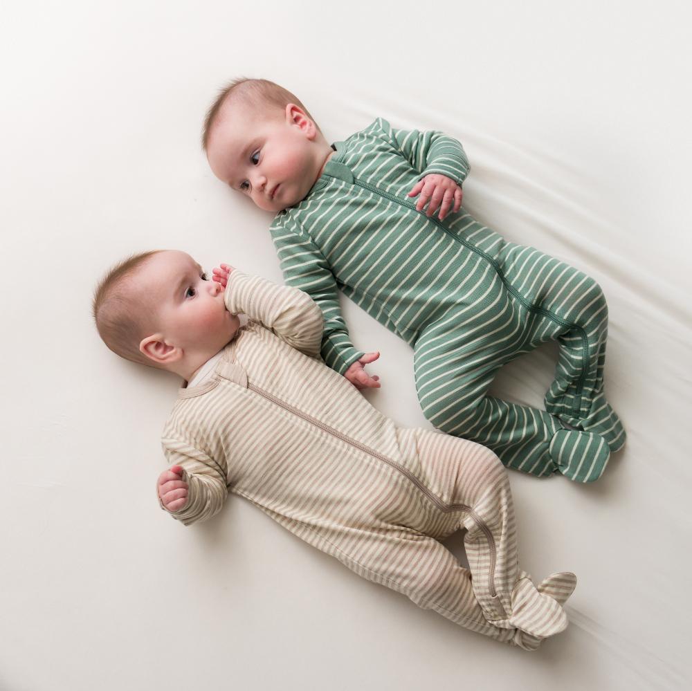 Two babies wearing striped merino footed onesies