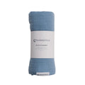 Blue muslin swaddle blanket with a label on a white background