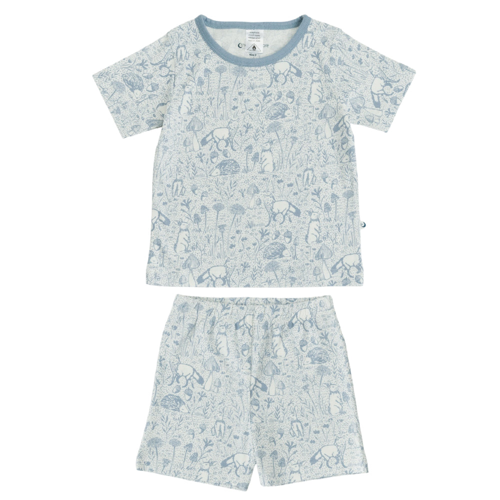Kids short sleeve pjs with a blue woodlands theme print on a white background. 