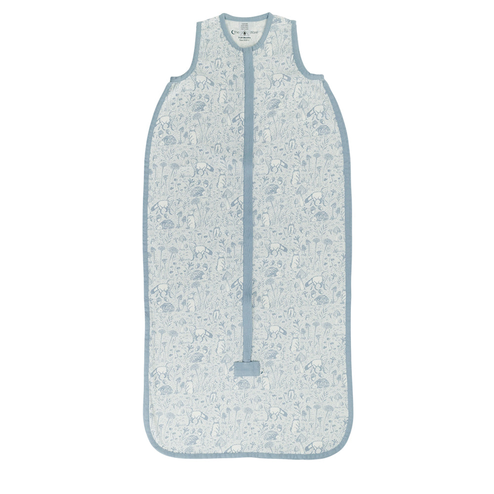 A blue baby sleeping bag with a all over woodlands theme print on a white background. 