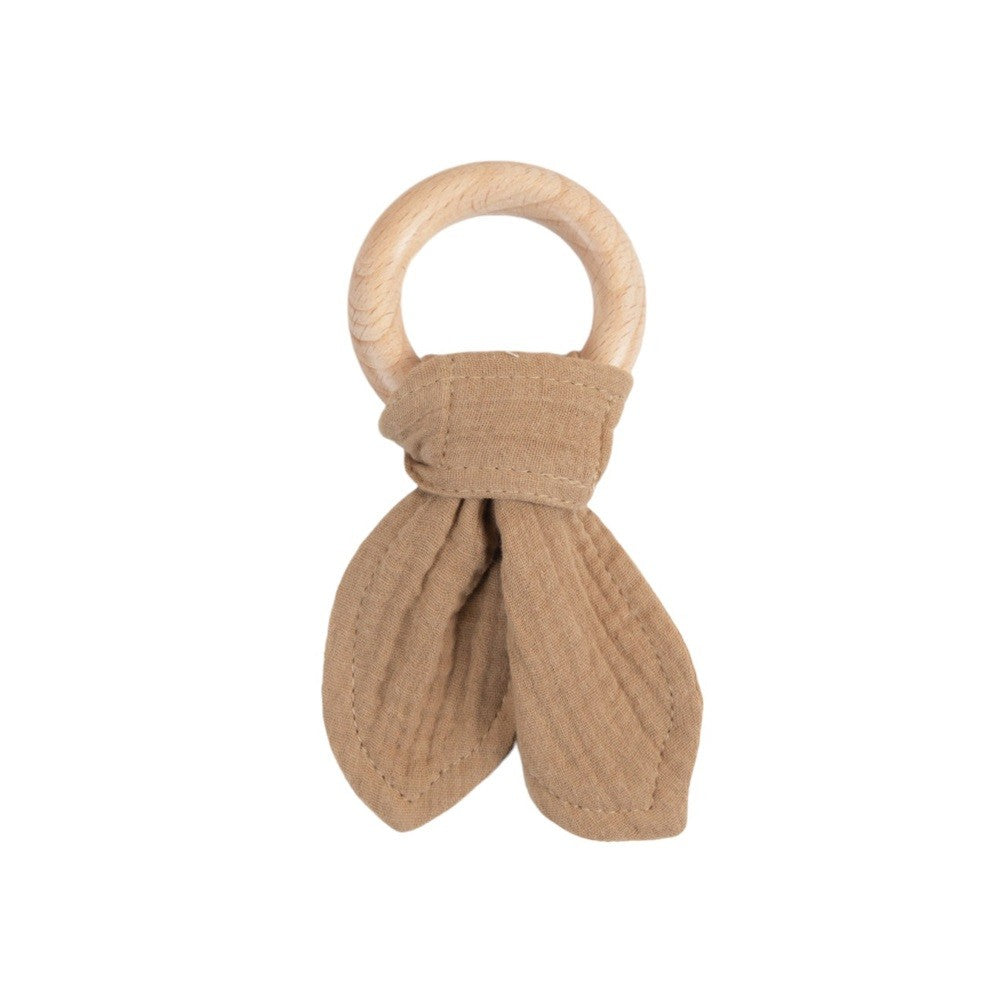 Wooden teething ring with brown knotted muslin fabric on a white background