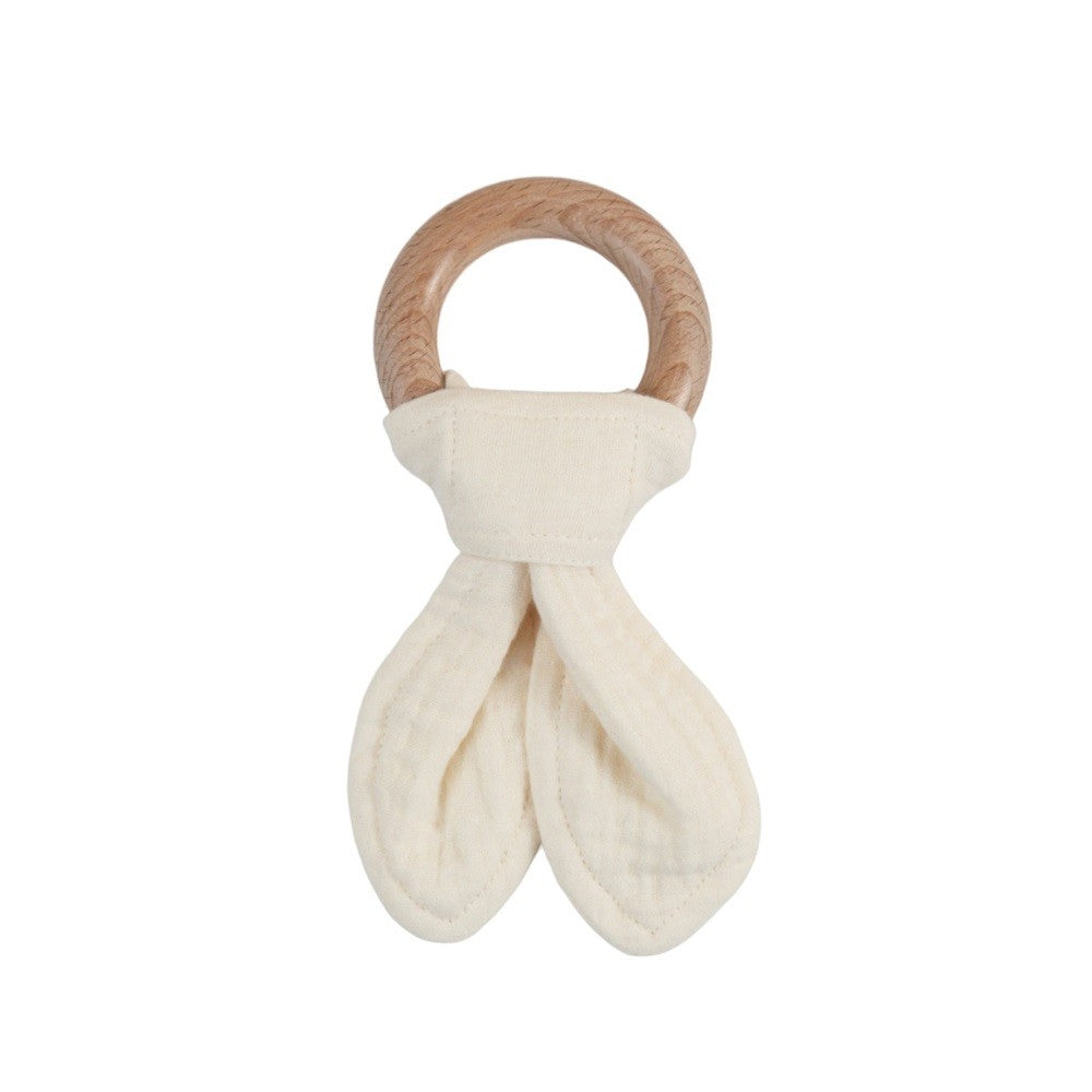 Baby teething ring with wooden handle and white fabric on a white background