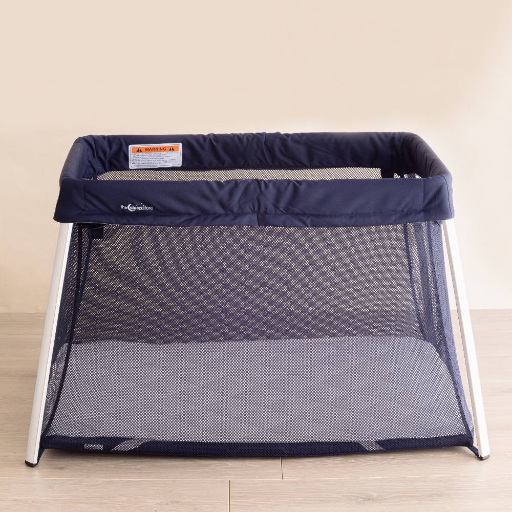 Quilted wool topper in a mesh travel cot