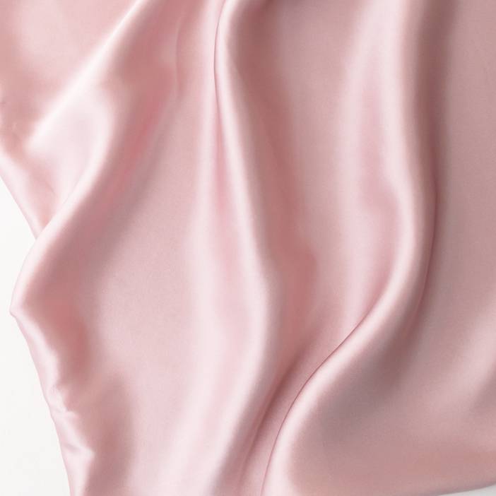 Close-up of pink satin fabric with a soft texture
