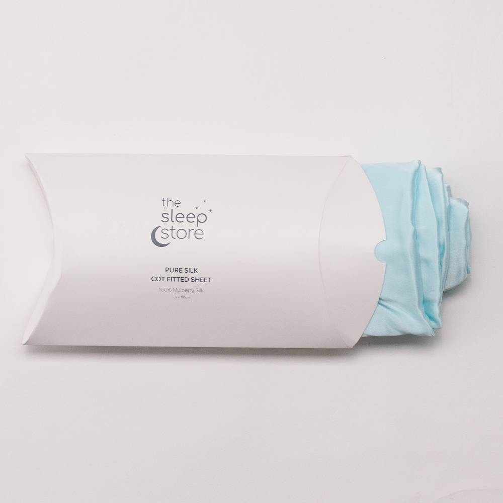 Roll of light blue silk cot fitted sheet with 'The Sleep Store' branding on a white background