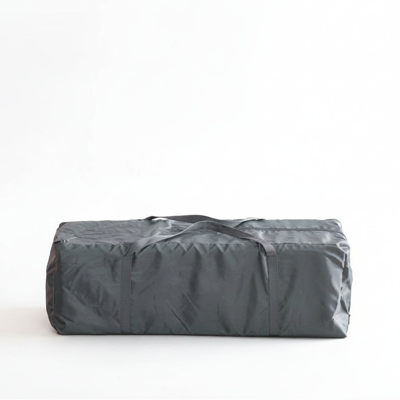 Gray Quest storage bag on a light-colored couch with a white background