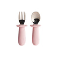 Set of pink baby's fork and spoon with silicone handles on a white background