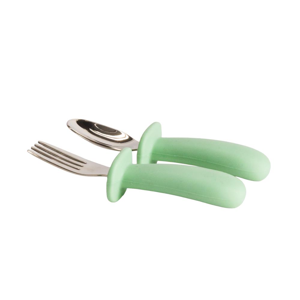Set of Nestling stainless steel baby silver fork and spoon with green handles on a white background