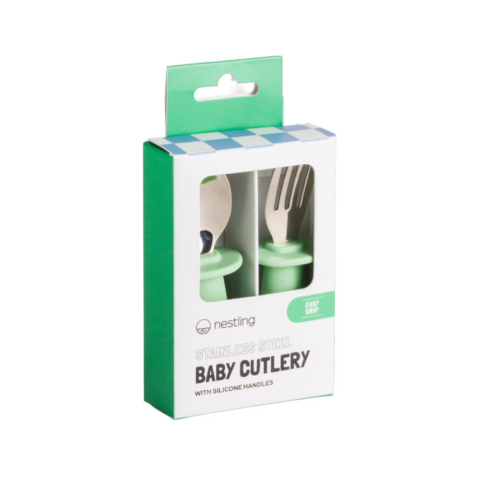 Box of Nestling stainless steel baby cutlery with green handles on a white background