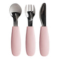 Set of three pink-handled Nestling toddler cutlery on a white background