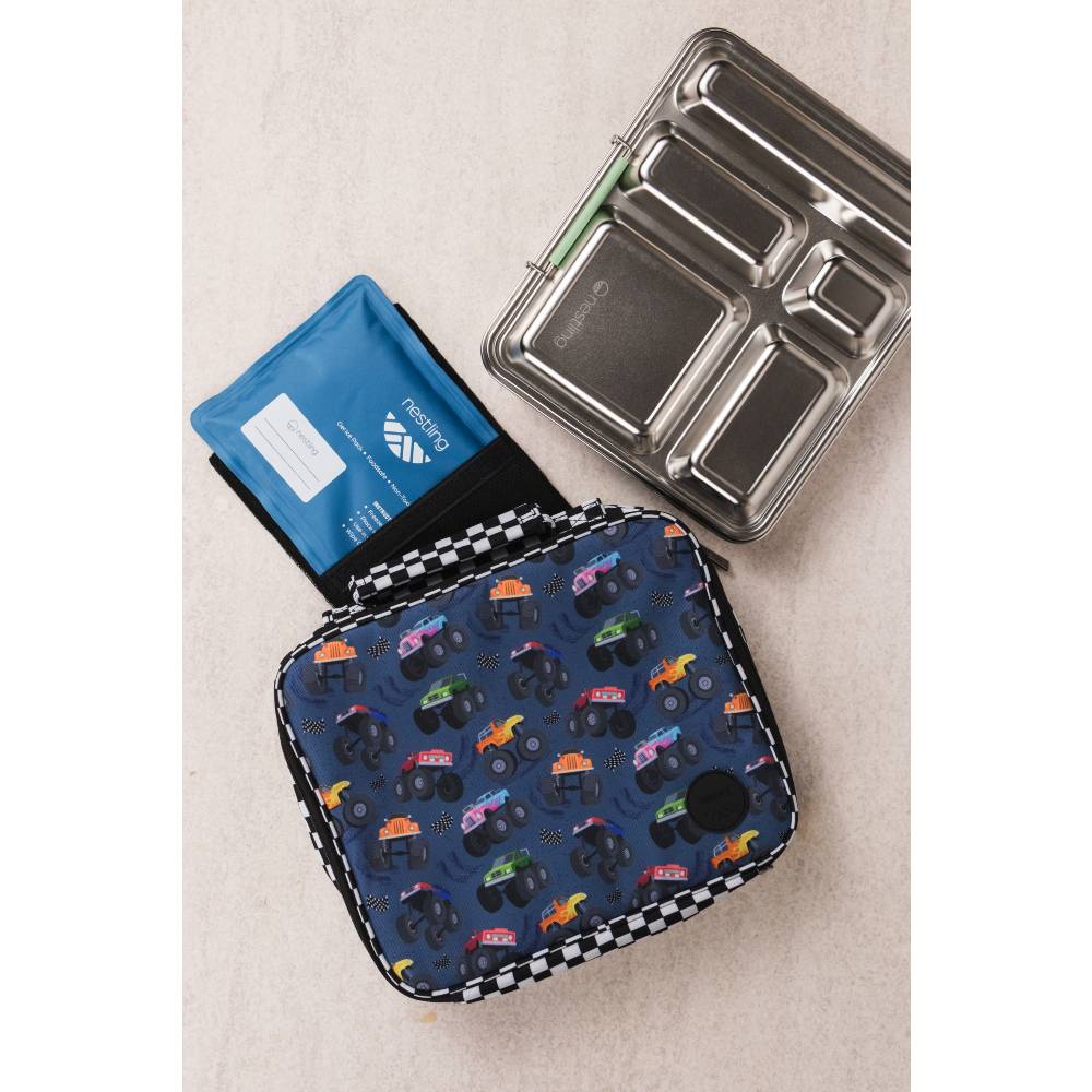 A navy blue lunch bag with a colorful monster truck pattern and a black-and-white checkered trim, alongside a blue ice pack and a stainless steel bento box.