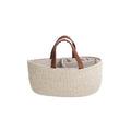 Beige woven basket with brown leather handles on a white background