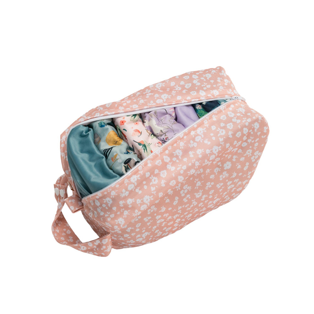Pink floral-patterned nappy pod with cloth nappies inside on a white background