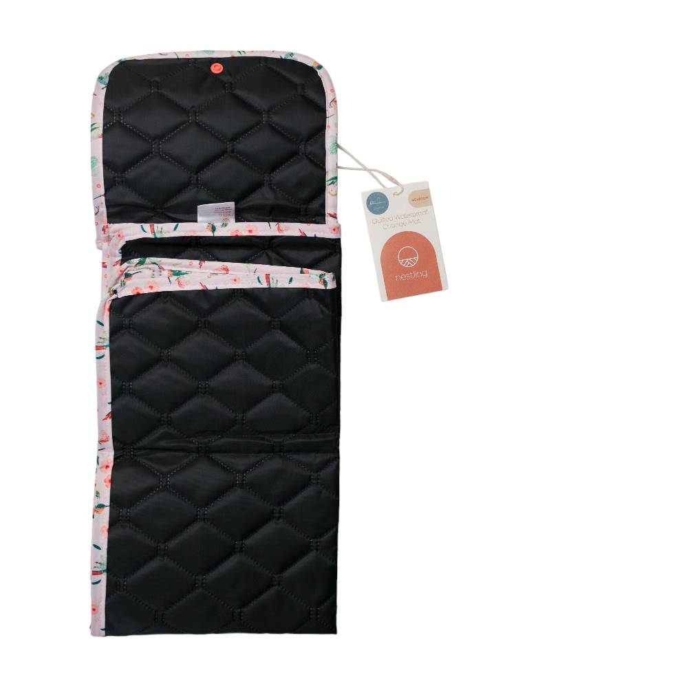 Reverse side of a quilted portable change mat with floral edge and tag on a white background