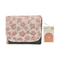 Floral-patterned Nestling portable quilted change mat with a tag on a white background